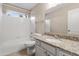 Bright bathroom featuring a tub-shower combo, granite countertop, and a white vanity at 662 S Saddle St, Gilbert, AZ 85233