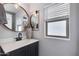 Bathroom with a round mirror over a vanity with a gray cabinet and a white countertop at 6907 S 8Th Dr, Phoenix, AZ 85041