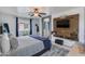 Bedroom featuring a TV on a wood accent wall and a gray upholstered bed with a blue blanket at 6907 S 8Th Dr, Phoenix, AZ 85041