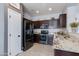 Well-equipped kitchen featuring dark cabinets, granite countertops, and stainless steel appliances at 6907 S 8Th Dr, Phoenix, AZ 85041
