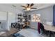 Office featuring dual desks, floating shelves, blue accent wall, and tile flooring at 6907 S 8Th Dr, Phoenix, AZ 85041