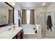 Bathroom featuring a tub-shower combination with a clear glass surround and neutral decor at 6932 W Harwell Rd, Laveen, AZ 85339