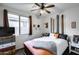 Cozy bedroom featuring a ceiling fan, window, and stylish décor, creating a relaxing atmosphere at 6932 W Harwell Rd, Laveen, AZ 85339