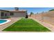 Backyard featuring artificial turf area, desert landscaping, and block fence at 701 W Mesquite St, Chandler, AZ 85225