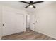 Bright bedroom with wood-look floors, ceiling fan, and closet with sliding doors at 701 W Mesquite St, Chandler, AZ 85225
