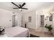 Spacious bedroom with ceiling fan and neutral decor leads to an ensuite bathroom with a tiled walk-in shower at 701 W Mesquite St, Chandler, AZ 85225