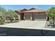 Stunning single-Gathering home with a three-car garage, lush landscaping, and desert plants at 7144 E San Cristobal Way, Gold Canyon, AZ 85118