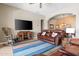 Spacious living room features a brown leather couch, TV, and colorful striped rug at 7144 E San Cristobal Way, Gold Canyon, AZ 85118