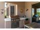 Covered outdoor kitchen boasts a built-in grill and counter space for cooking and entertaining at 7144 E San Cristobal Way, Gold Canyon, AZ 85118