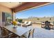 Inviting covered patio featuring a dining area and lounge chairs with views of a landscaped backyard at 7144 E San Cristobal Way, Gold Canyon, AZ 85118