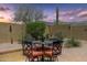 Cozy patio with a dining table surrounded by lush desert landscaping and a private wall at 7144 E San Cristobal Way, Gold Canyon, AZ 85118