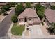 Attractive home featuring a lush lawn, complemented by mature trees, a three-car garage, and inviting curb appeal at 7272 W Crystal Rd, Glendale, AZ 85308