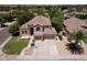Beautiful home showcasing a well-manicured lawn, mature trees, complemented by a three-car garage and ample parking space at 7272 W Crystal Rd, Glendale, AZ 85308