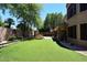 Lush backyard featuring artificial grass and a stone fountain, ideal for entertaining guests outdoors at 7272 W Crystal Rd, Glendale, AZ 85308