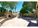 Backyard featuring an outdoor fireplace, seating area, and mature landscaping for a tranquil retreat at 7272 W Crystal Rd, Glendale, AZ 85308