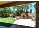 Backyard featuring an outdoor fireplace, seating area, and mature landscaping for a tranquil retreat at 7272 W Crystal Rd, Glendale, AZ 85308