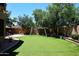 Large backyard featuring a well-maintained lawn, mature trees, and a charming swing set at 7272 W Crystal Rd, Glendale, AZ 85308