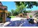 Expansive backyard with a stone fireplace, comfortable seating, and lush artificial grass at 7272 W Crystal Rd, Glendale, AZ 85308