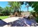Backyard featuring an outdoor fireplace, seating area, and mature landscaping for a tranquil retreat at 7272 W Crystal Rd, Glendale, AZ 85308