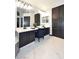 Modern bathroom featuring dual sinks, white counters, dark cabinetry, and a vanity seating area at 7272 W Crystal Rd, Glendale, AZ 85308