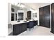 Modern bathroom featuring dual sinks, white counters, dark cabinetry, and a vanity seating area at 7272 W Crystal Rd, Glendale, AZ 85308