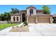Inviting two-story home with a three-car garage, stone accents, and well-manicured front yard at 7272 W Crystal Rd, Glendale, AZ 85308