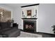 Close up of living room fireplace with dark wood mantle and gray sectional at 7272 W Crystal Rd, Glendale, AZ 85308