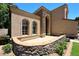 Charming home exterior with stone details, arched windows, and a curved patio at 7272 W Crystal Rd, Glendale, AZ 85308