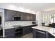 Well-equipped kitchen features dark wood cabinets, granite counters and backsplash and stainless appliances at 7272 W Crystal Rd, Glendale, AZ 85308