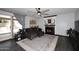 Living room with cozy fireplace, ceiling fan, gray sectional and sliding glass door at 7272 W Crystal Rd, Glendale, AZ 85308