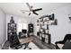 A lovely home office with multiple shelves displaying artwork and decor, and a modern ceiling fan at 7272 W Crystal Rd, Glendale, AZ 85308