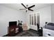 Office with black ceiling fan, desk and chair, sitting chair and window with plantation shutters at 7272 W Crystal Rd, Glendale, AZ 85308
