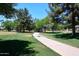 Scenic walking path winds through a grassy park with mature trees, ideal for leisurely strolls at 7272 W Crystal Rd, Glendale, AZ 85308