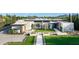 Expansive aerial view of a modern home with manicured lawns, desert landscaping, and a geometric design at 7341 E Sunnyside Dr, Scottsdale, AZ 85260