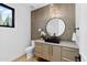 Stylish powder room featuring a unique round mirror, vessel sink, and accent wall with textured tile at 7341 E Sunnyside Dr, Scottsdale, AZ 85260
