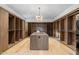 Large walk-in closet with custom shelving, a central island, and elegant lighting at 7341 E Sunnyside Dr, Scottsdale, AZ 85260