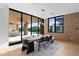 Contemporary dining room featuring a wooden table, brick accents, and sliding glass doors to the outside at 7341 E Sunnyside Dr, Scottsdale, AZ 85260