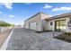 Contemporary home with gray brick driveway, white garage doors, and landscaped entryway at 7341 E Sunnyside Dr, Scottsdale, AZ 85260
