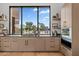 Modern kitchen with custom cabinets, sink with large window, and views of backyard at 7341 E Sunnyside Dr, Scottsdale, AZ 85260