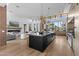 Open-concept kitchen with island, modern lighting, and open living area with fireplace at 7341 E Sunnyside Dr, Scottsdale, AZ 85260