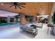 Expansive covered patio with outdoor seating, ceiling fans, brick pillars, and a view of the pool at 7341 E Sunnyside Dr, Scottsdale, AZ 85260