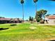 Exterior view with manicured lawn, trees, and well-maintained condo building in a lush community at 7409 N Via Camello Del Norte -- # 138, Scottsdale, AZ 85258
