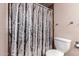 This home features a bathroom with a shower and unique tree-patterned shower curtain at 7755 W Cora Ln, Phoenix, AZ 85033