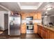 Well lit kitchen with stainless steel appliances, granite countertops, and beautiful wood floors at 7755 W Cora Ln, Phoenix, AZ 85033