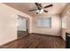 This open living space features wood floors, neutral paint, and a ceiling fan at 7755 W Cora Ln, Phoenix, AZ 85033