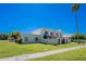 Well-maintained home featuring a lush lawn, mature palm trees, and a charming exterior facade at 7830 E Valley Vista Dr, Scottsdale, AZ 85250