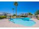 Community pool with lounge chairs and umbrellas amid lush landscaping and community buildings at 7830 E Valley Vista Dr, Scottsdale, AZ 85250