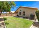 Lush backyard featuring green grass, mature trees, a brick privacy fence, and an AC unit at 7930 W Wescott Dr, Glendale, AZ 85308