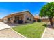 Well-maintained backyard featuring green grass, a covered patio, and a block wall for privacy at 7930 W Wescott Dr, Glendale, AZ 85308