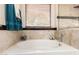 Bright bathroom featuring a soaking tub with tile surround and a window for natural light at 7930 W Wescott Dr, Glendale, AZ 85308